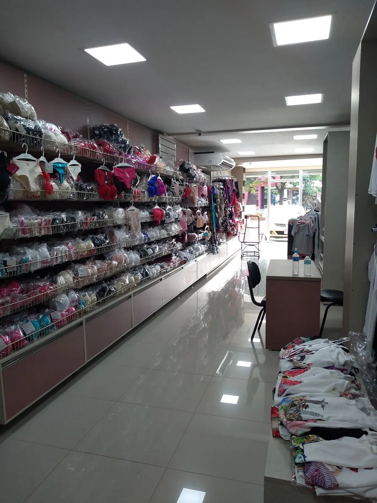 Pasillo del salón con lencería en las perchas y piso blanco