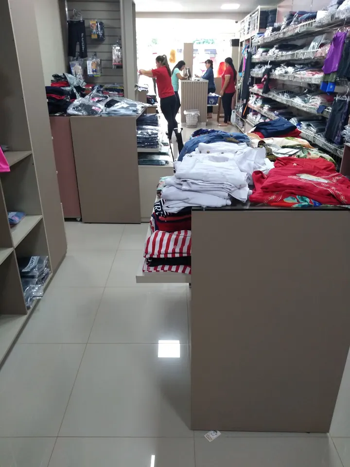 Mesas con remeras y prendas dobladas dentro del local